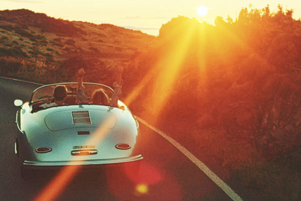 Couple driving into California sunset