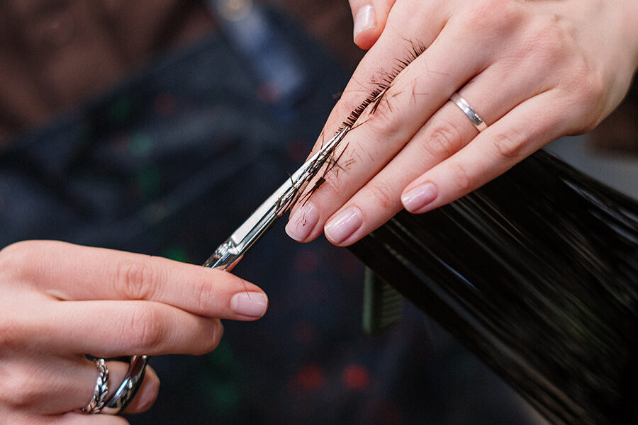 Woman cutting hair with pretty nails